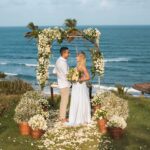 A bride and groom eloping on a beach.