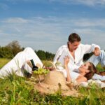 A couple laying on the grass having a picnic.