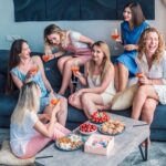 A group of girls at a bachelorette party with food and wine.