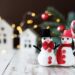 A table with mini snowman and christmas village houses.