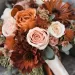 A burnt orange, rust orange, and dusty pink colored wedding bouquet.