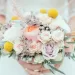 A bride holding a colorful spring wedding bouquet.