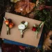 A table with fall leaves and 2 rustic fall wedding boutonnieres.