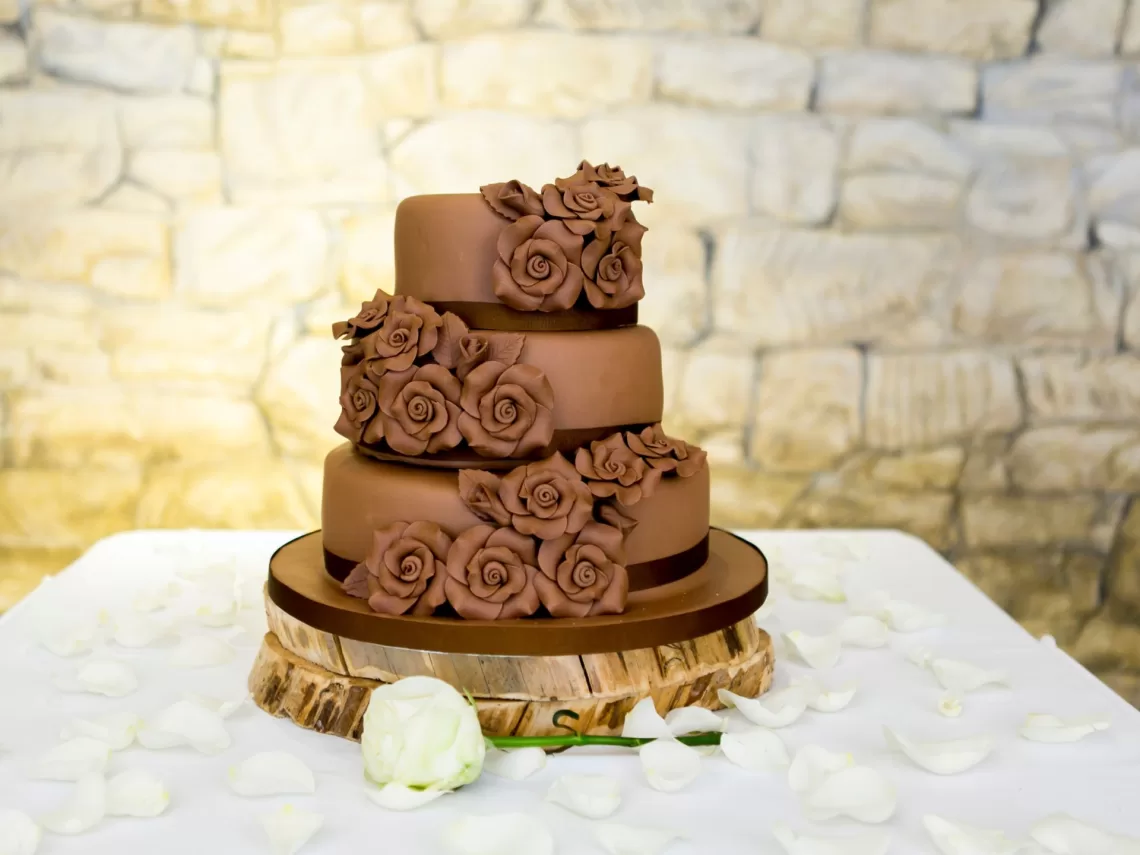 A table with a chocolate wedding cake.
