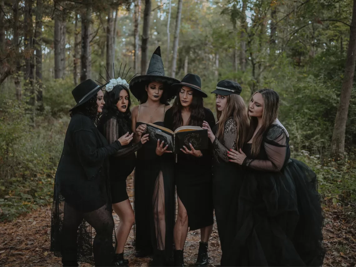 A bride and her bridesmaids in witch costumes for the bride's halloween bachelorette.