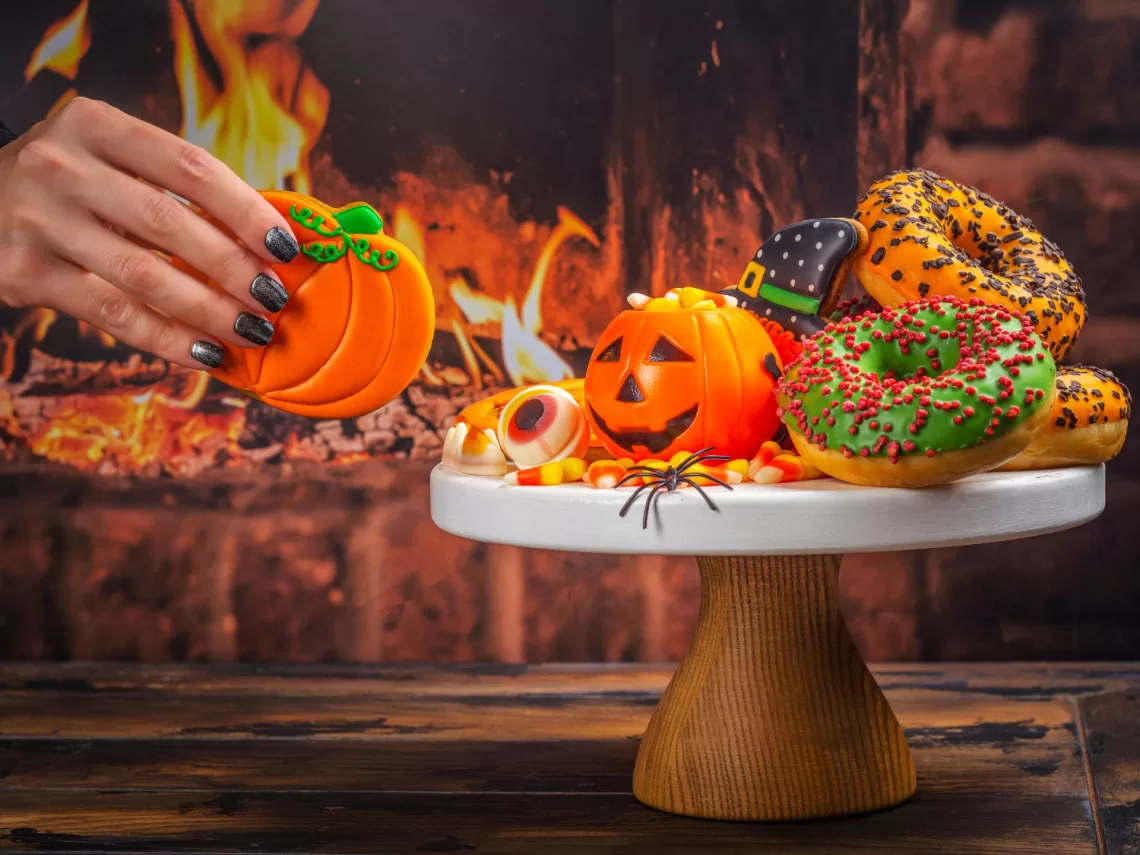 A women platting halloween decorated cookies.