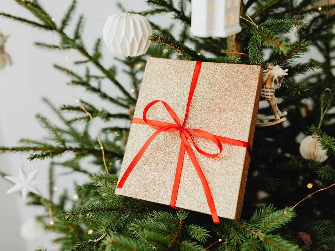 A christmas tree with a gold and red christmas present.