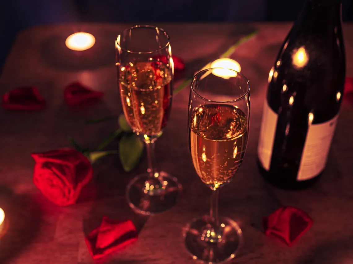 A table with champagne and roses.