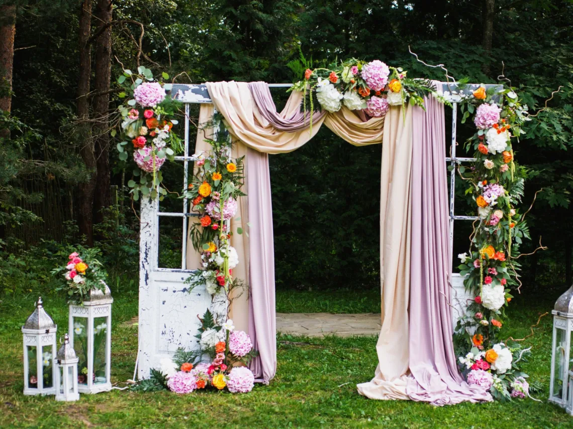 A wedding arch with pastel floral garland.